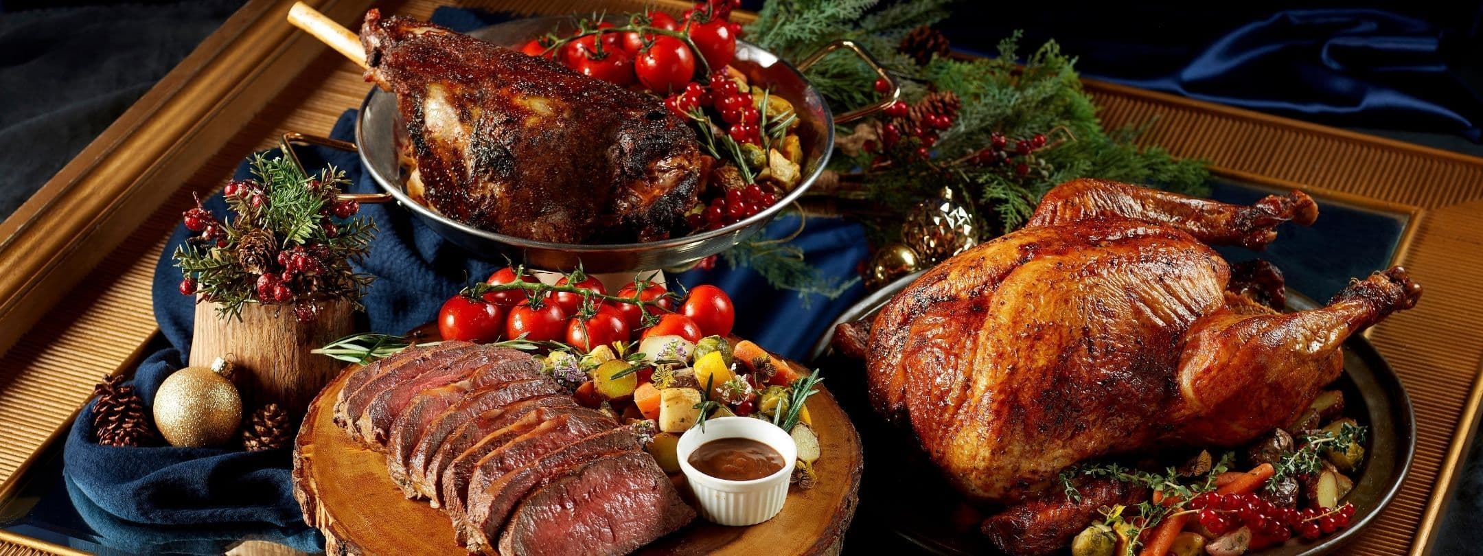 A festive holiday spread with roasted turkey, sliced beef, and another roast with cranberries.